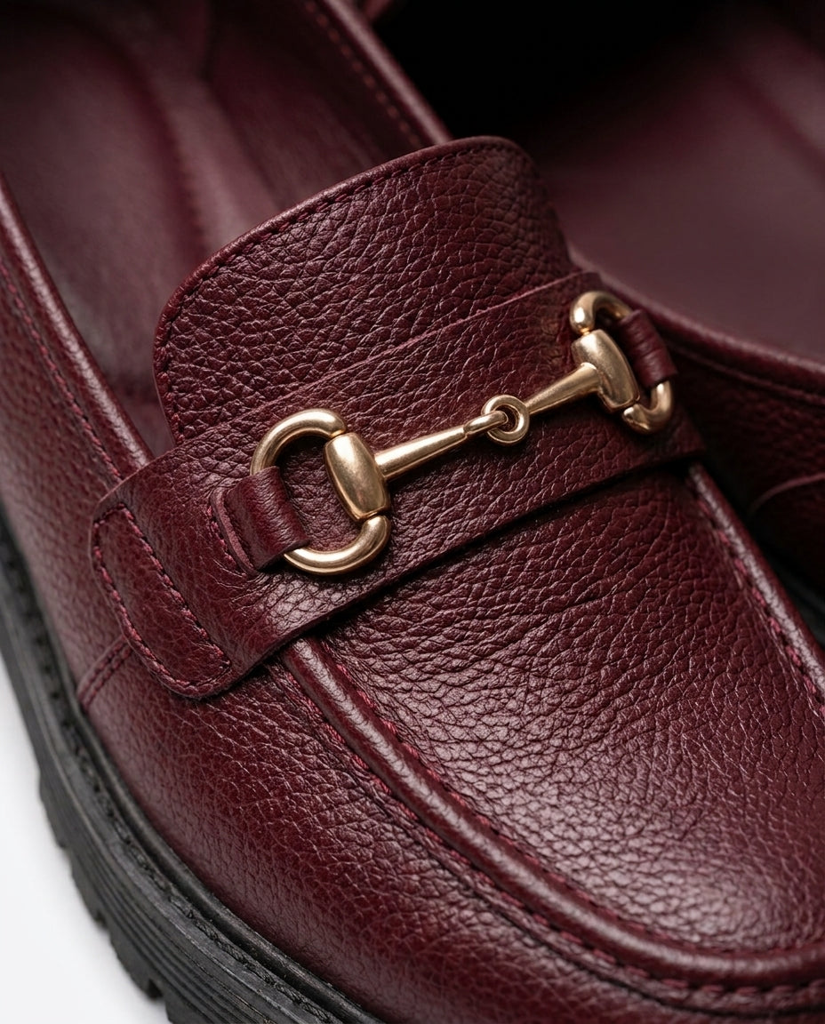 Mocasín Traviesa burdeos, detalle de la piel granulada y el bocado dorado